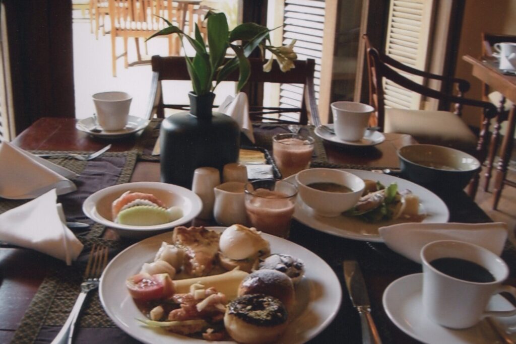 ホテルの朝ごはんの写真　パンやフルーツ、パスタなどがお皿にのっている